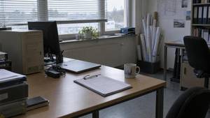 Leeres Ingenieurbüro am Samstag: alter Rechner und neuer Laptop auf einem Schreibtisch, daneben Klemmbrett mit Checkliste und Tasse